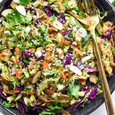 a salad with carrots, lettuce and other vegetables in a black bowl