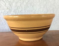 a yellow bowl sitting on top of a wooden table