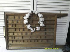 a wreath made out of cotton sitting on top of a wooden door