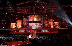 the stage at awards is lit up with red lights and people standing in front of it