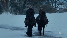 two people are riding horses in the snow