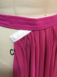 a woman's pink skirt with the name c on it is shown in front of a mannequin