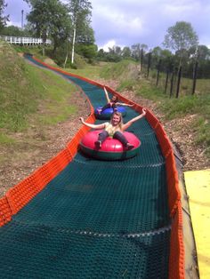 two people riding on an inflatable tube down a hill