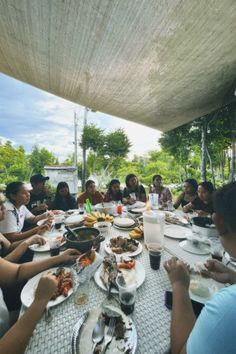 a group of people sitting around a table eating food