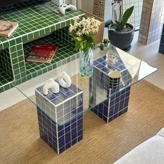 two glass tables with vases and flowers on them