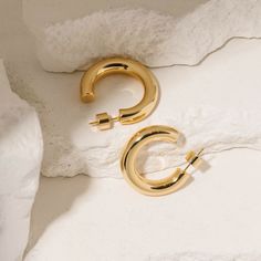 This is the Perfect Hoop you've been looking for. This series of chunky hoop earrings comes in a range of sizes that are perfectly suited for each unique style. And to make them even more perfect, we've made them light as air and oh so comfortable to wear. Inspired by our undying love of golden hoops. Sold as a pair. Crafted with 18K triple-layered gold over brass; enhanced with a fourth-layer PVD coating. Features our signature smooth, snug cylindrical backings for securely fitting your perfect hoop. Closure: push back Finish: high polish  DAILY CARE Keep your hoops in their best condition by removing them before exercising or showering. It is also best to apply perfumes, creams, and hair care products before putting on your hoop earrings. We pride ourselves on the quality of our products Golden Hoops, Pvd Coating, Undying Love, Chunky Hoop Earrings, Open Hoop Earrings, Malta, Unique Style, Hoop Earrings, Product Description