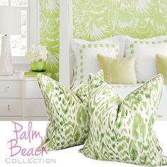 two green pillows sitting on top of a white bed