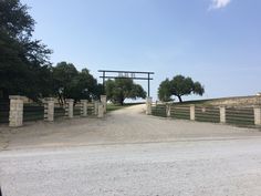 an open gate leading to a dirt road