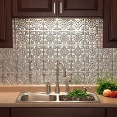 a stainless steel backsplash in a kitchen with dark wood cabinets and white counter tops