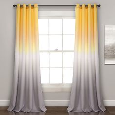 a window with yellow and grey curtains in front of a white wall next to a wooden floor