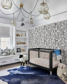 a baby's room with blue carpet and wallpaper, including a crib