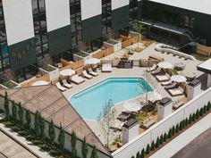 an aerial view of a hotel pool with lounge chairs and umbrellas next to it