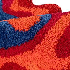 an orange, blue and red rug on the floor