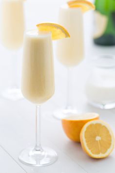 three glasses filled with orange juice and garnished with an orange slice