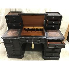 an antique desk with two drawers and a drawer on the top, is shown in black