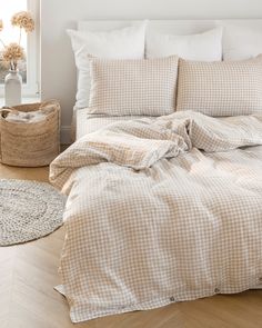 an unmade bed in a bedroom with white walls