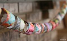 some rolls of toilet paper are hanging on a clothes line in front of a brick wall