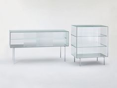 two glass shelves sitting next to each other in front of a white wall and floor