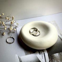 two wedding rings on top of a white object