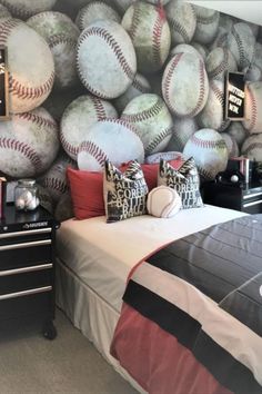 a baseball themed bedroom with lots of balls on the wall and bed in front of it