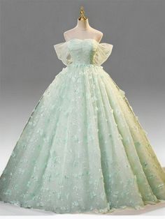 Celebrate elegance in this Mint Green Evening Dress, designed to exude sophistication and grace at every turn. Crafted from layers of soft, mint green tulle, this gown is adorned with exquisite floral appliqués that cascade down its length, adding depth and enchantment to the fabric's gentle flow. The bodice features a structured corset that cinches at the waist, creating a flattering silhouette that celebrates the fullness of plus-size figures. This corset is not only a nod to classic style but also ensures a perfect, tailored fit, enhancing comfort and confidence. The dress's romantic off-shoulder design, complemented by airy butterfly sleeves, frames the neckline beautifully, adding a touch of delicate charm. Flowing effortlessly to a floor-length finish, the skirt swirls with every ste Seafoam Green Wedding Dress, Princess Ball Gowns Green, Blue Debut Dress, Light Green Princess Dress, Light Green Ball Gown, Light Green Wedding Dress, Sage Green Ball Gown, Mint Green Wedding Dress, Mint Green Gown