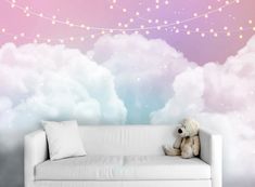 a teddy bear sitting on top of a white couch in front of a wall mural