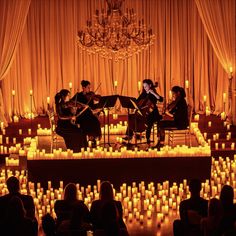 a group of people playing instruments in front of candles