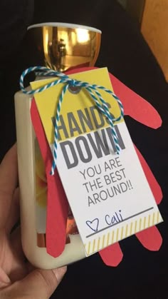 a person holding up a card with a sign on it that says hand down you are the best around