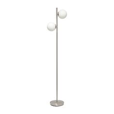 a metal floor lamp with three white balls on it's base and one light bulb