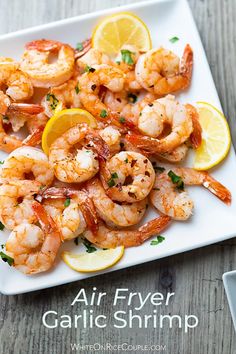 air fryer garlic shrimp on a white plate with lemon wedges