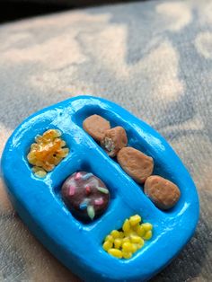 a blue toy boat with candy and candies in it's tray on a table