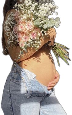 a pregnant woman with flowers in her stomach and jeans on the side, holding an arm over her belly