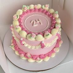 a pink and white cake sitting on top of a table