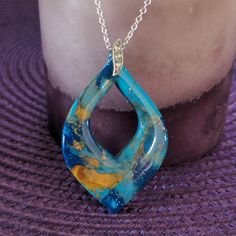 a blue and yellow pendant sitting on top of a purple table