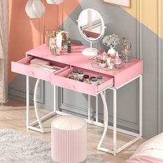 a pink desk with two drawers and a mirror on it in front of a wall