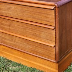 a wooden dresser sitting on top of green grass