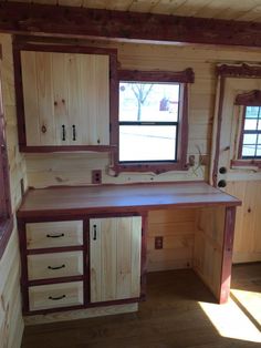 a kitchen area with wooden cabinets and windows