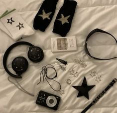 an assortment of items laid out on a bed with headphones, socks and other accessories