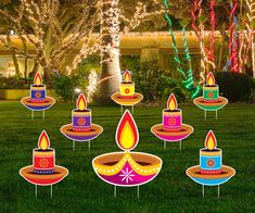 lighted birthday candles on lawn in front of trees