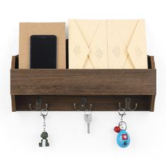 a wooden shelf with key hooks and two cell phones hanging from it's sides