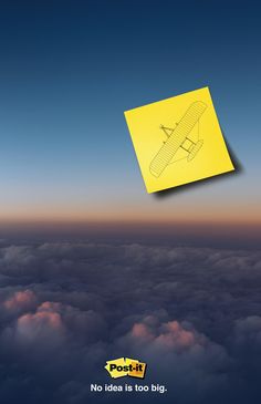 a yellow post - it note sitting on top of an airplane in the sky above clouds