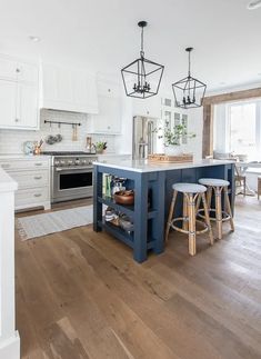 a kitchen island with stools in front of it next to a stove top oven