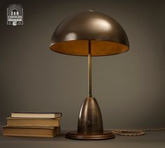 a lamp sitting on top of a table next to a pile of books and a chain