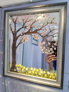 a person taking a photo of a tree in a mirror