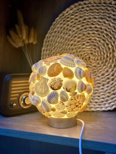 a light that is sitting on top of a shelf next to a cell phone and some shells