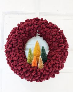 a christmas wreath with small trees on it