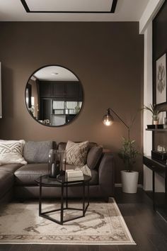 a living room filled with furniture and a round mirror on the wall above it's coffee table