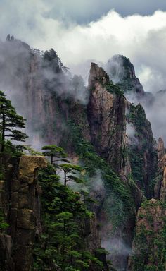 the mountains are covered in fog and clouds