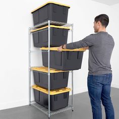 a man is holding three bins on a shelf with yellow shelves next to it