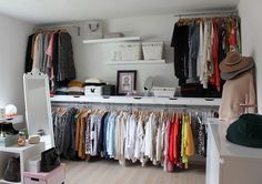 an organized closet with clothes and hats